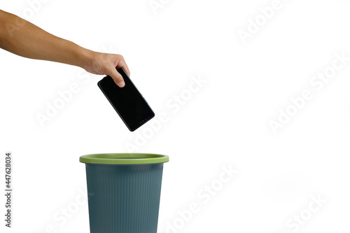 Man hand throws cell phone into trash can on white background.