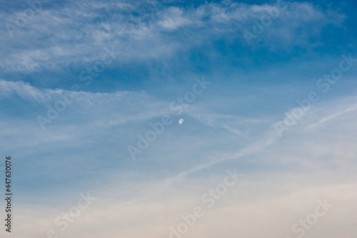 The moon and white cirrus clouds in the blue sky © Valery Kleymenov