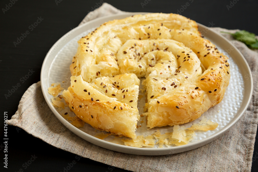 Homemade Balkan Pie with Feta and Sesame Seeds on a plate, side view. Homemade Balkan Pie with Feta and Sesame Seeds on a plate, side view.