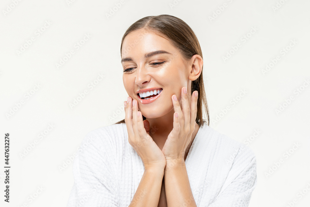 Smiling beautiful Caucasian woman touching her face on isolated studio white background for beauty and skin care concepts Smiling beautiful Caucasian woman touching her face on isolated studio white background for beauty and skin care concepts