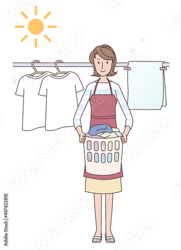 晴天に洗濯物を干すエプロン姿の若い女性