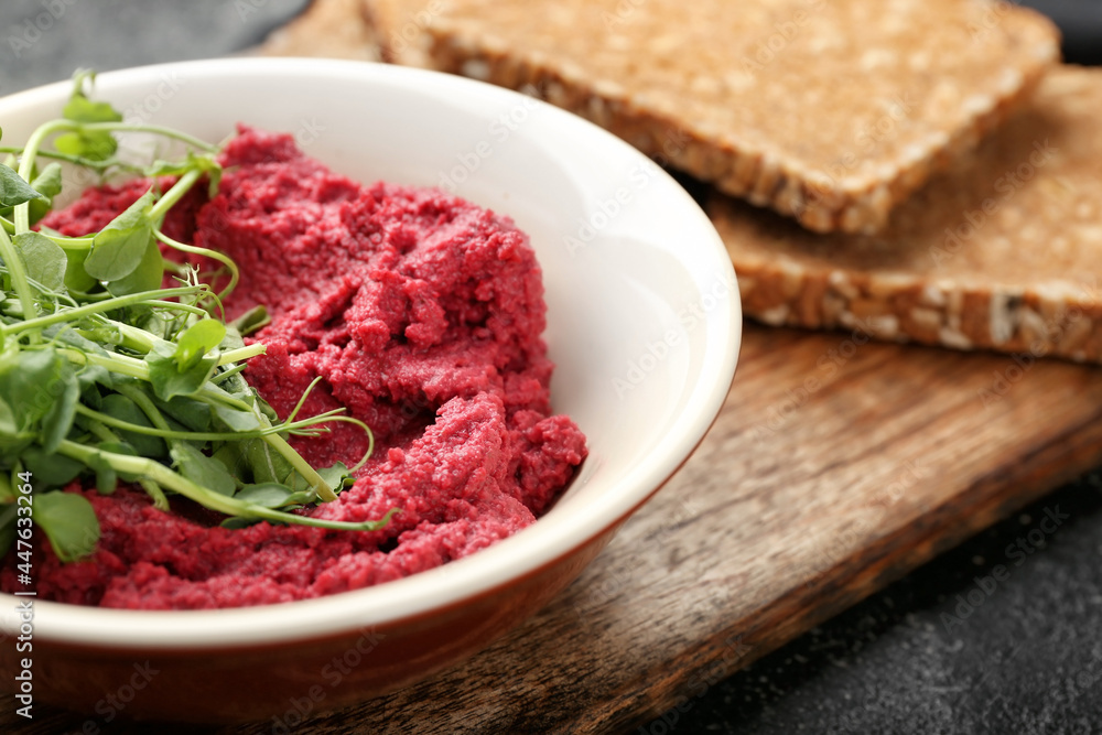 Bowl with tasty beet hummus, fresh sprouts and bread on dark background, closeup Bowl with tasty beet hummus, fresh sprouts and bread on dark background, closeup