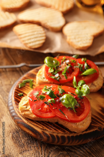 Tasty bruschettas with tomato and hummus on wooden background  closeup