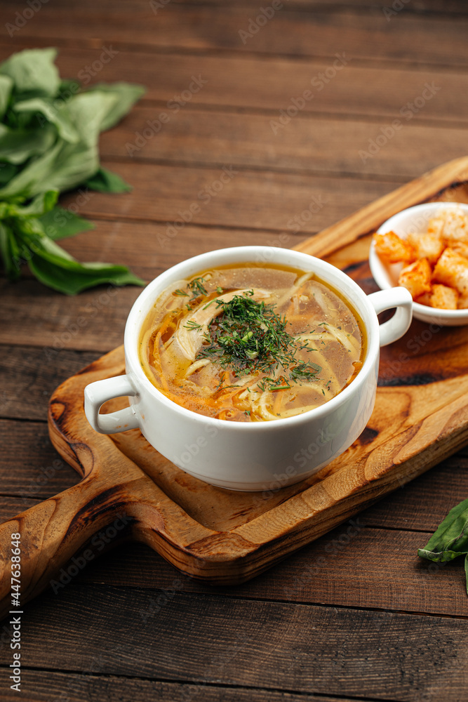 Chicken noodle soup with croutons on wooden background Chicken noodle soup with croutons on wooden background
