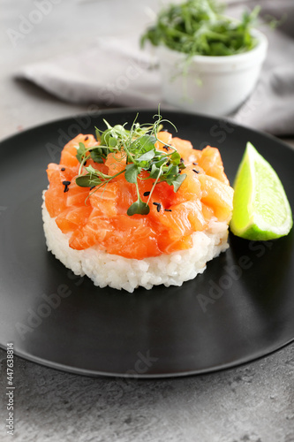 Delicious salmon tartar on grunge background, closeup