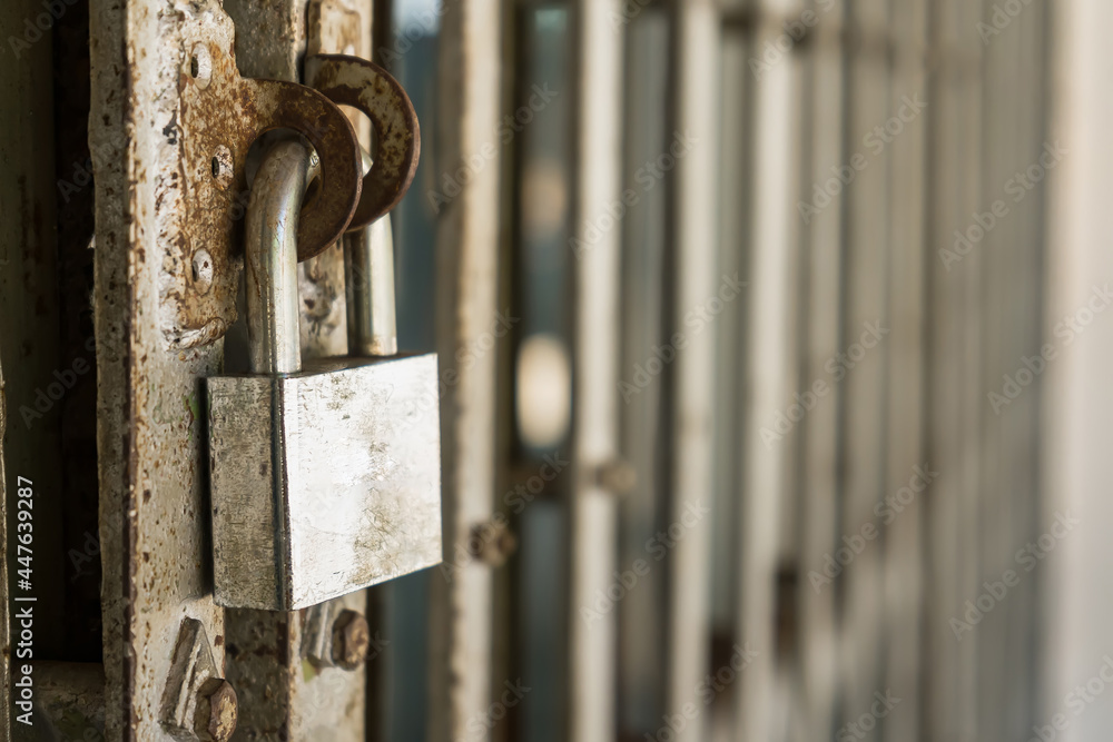 Old master key locked on iron gate, Steel padlock, Close up selective focus, Soft background blur. Old master key locked on iron gate, Steel padlock, Close up selective focus, Soft background blur.