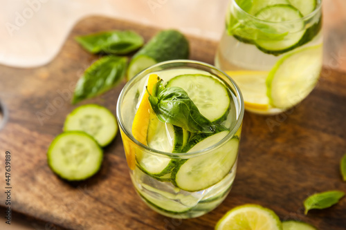 Glasses with cucumber lemonade on wooden background
