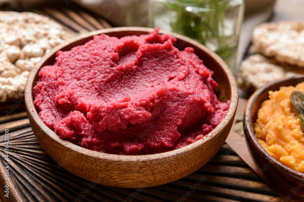 Bowls with tasty beet hummus on table, closeup Bowls with tasty beet hummus on table, closeup