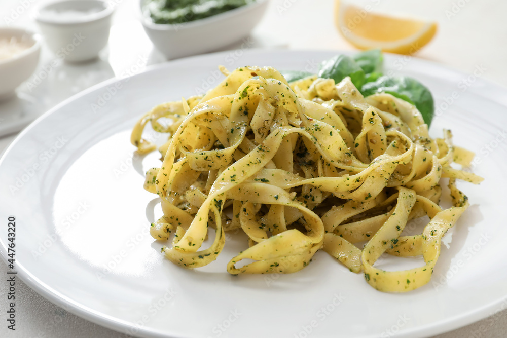Plate with tasty pesto pasta on table