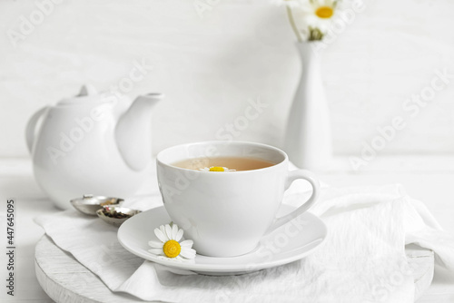 Composition with cup of floral tea on light background