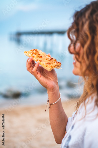 A young girl eating a coca de San Juan on the beach, a typical meal to celebrate San Juan night the summer solstice photo