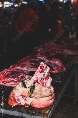 Pig's head butchered ready to sale at the Bac Ha Market. backgound blurry and unrecognizable person