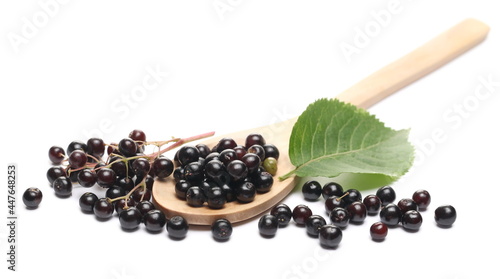 Elderberries, elder berries pile with green leaf and wooden spoon, isolated on white background