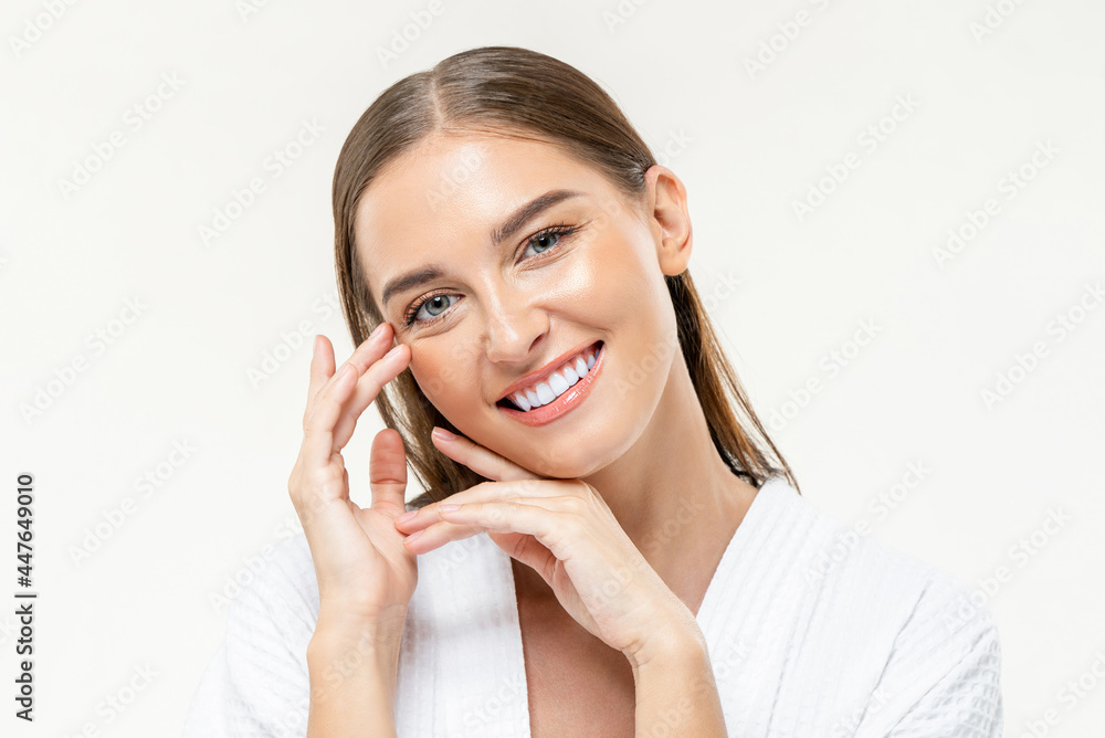 Beautiful Caucasian woman smiling with hands touching her face in isolated studio white background for skin care and beauty concepts Beautiful Caucasian woman smiling with hands touching her face in isolated studio white background for skin care and beauty concepts