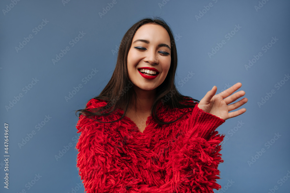 Stylish girl with brunette long hairstyle and red lipstick in fluffy fashionable outfit laughing and posing with closed eyes.. Stylish girl with brunette long hairstyle and red lipstick in fluffy fashionable outfit laughing and posing with closed eyes..