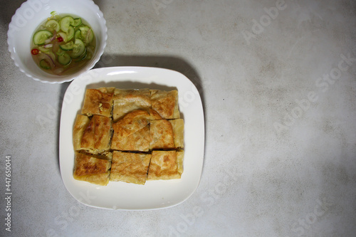 Chicken Murtabak is placed in a white plate. Chicken Murtabak is a very delicious Muslim food.