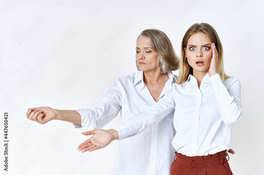 cute grandmother and granddaughter studio posing fun light background