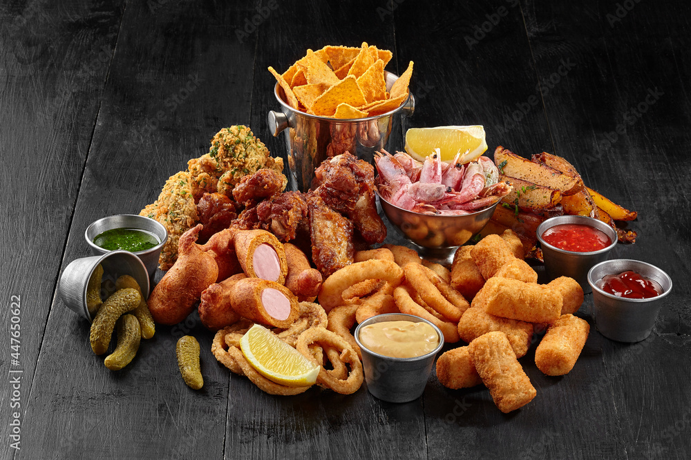 Fried chicken wings, battered sausages, onion rings, cheese sticks, potato wedges, corn chips and shrimps