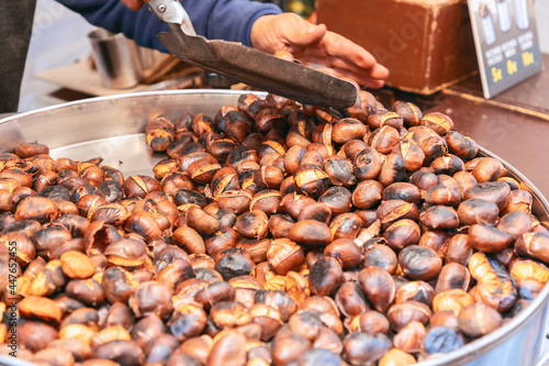 Chestnuts in a pan during charcoal roasting at a street food market. Charcoal roasting of chestnuts (Selective focus)