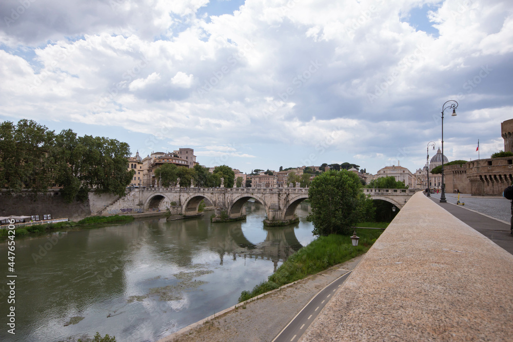Panoramic of St. Angelo Bridge on cloudy day in summer 2021 Italy.Pedestrian bridge, built in 134 A.D., with travertine marble fascias and spanning the River Tiber. Panoramic of St. Angelo Bridge on cloudy day in summer 2021 Italy.Pedestrian bridge, built in 134 A.D., with travertine marble fascias and spanning the River Tiber.