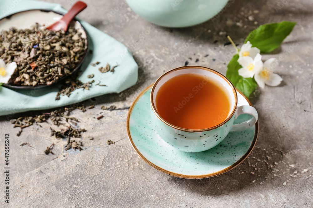 Cup of jasmine tea and dry leaves on grunge background Cup of jasmine tea and dry leaves on grunge background