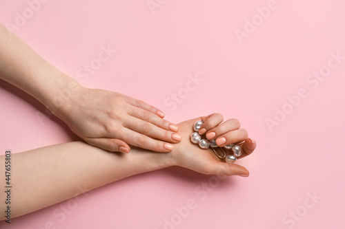 Hands with beautiful manicure and bracelet on color background