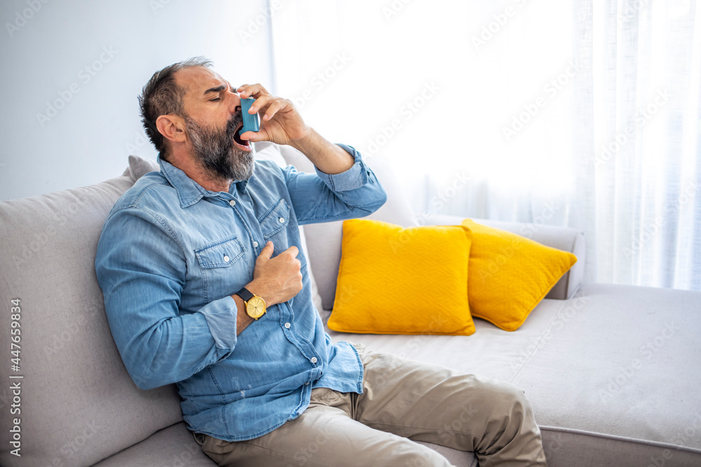 Portrait of a man with an asthma inhaler in his hands, an asthmatic attack. The concept of treatment of bronchial asthma, cough, allergies, dyspnea. Man using an asthma pump Portrait of a man with an asthma inhaler in his hands, an asthmatic attack. The concept of treatment of bronchial asthma, cough, allergies, dyspnea. Man using an asthma pump