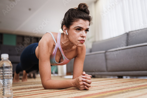 Attractive young Latin woman doing yoga stretching yoga at home. Healthy lifestyle concept.