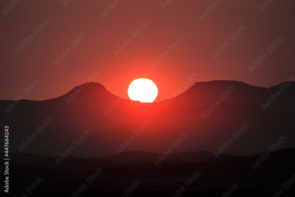 incredible view of setting sun above mountains in africa during sunset, red sky