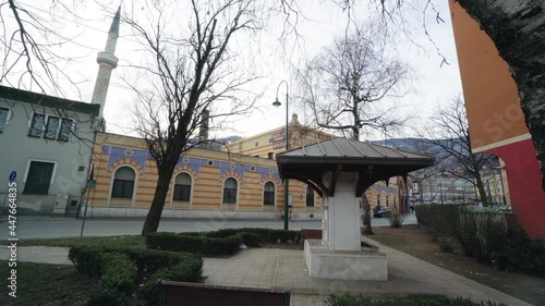 Water fountain in the park in Sarajevo with view of the Emperior mosque minaret in the background photo