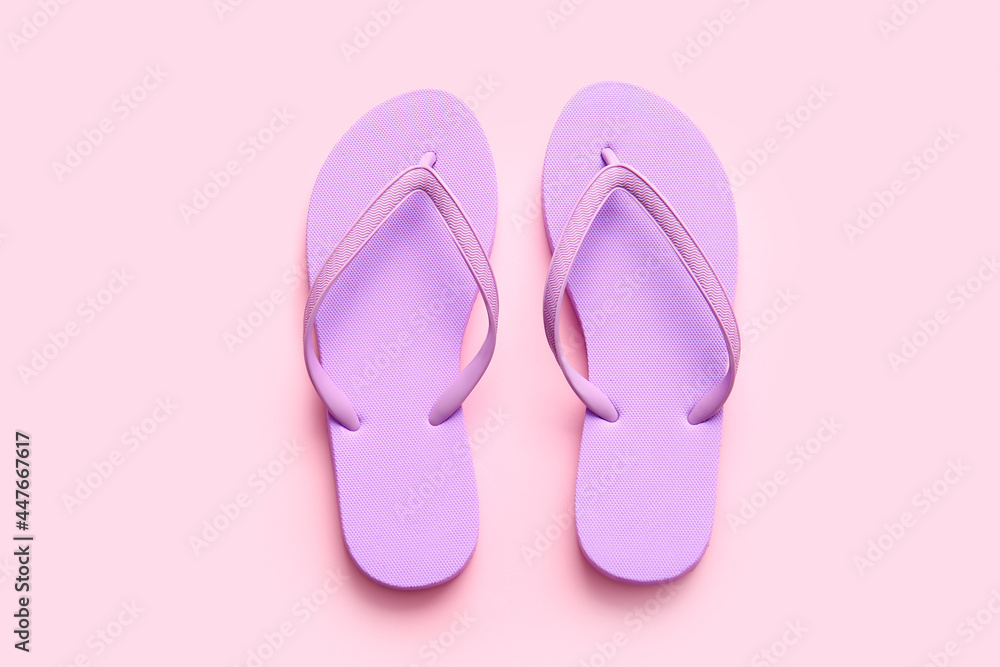 Stylish flip-flops on color background