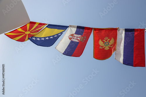 Flags of Balkan Countries And Russia Swaying Together Against The Blue Sky photo