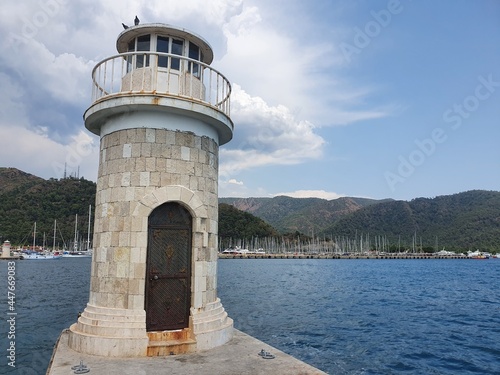 A small lighthouse in a bay by the sea.  The lighthouse serves as a signpost for sailors.