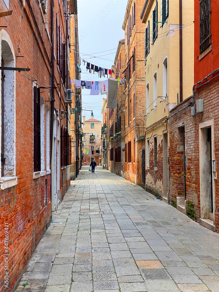 Fototapeta premium Colorful dead end street in Venice with lots of laundry hanging out to dry in lines stretched between the houses