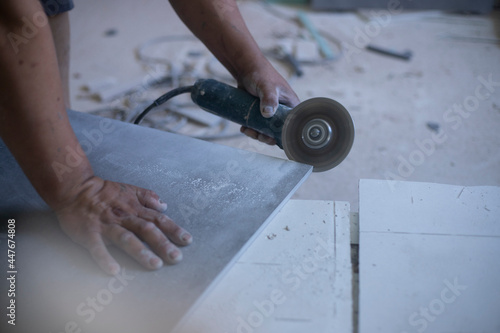 hands of latin worker cutting with an electric grinder
