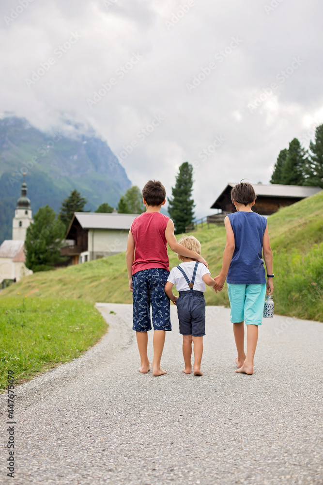 Happy family in Switzerland, walking on a mountain little road, going on vacation Happy family in Switzerland, walking on a mountain little road, going on vacation