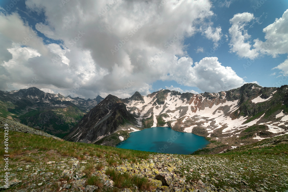 high-mountainous Murudjinskie lakes against the background of mountain peaks and remnants of snow and the sky with clouds