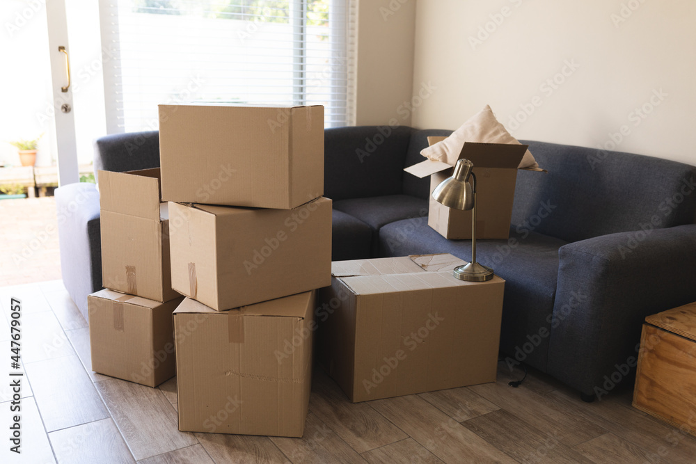 Pile of boxes prepared before moving house next to couch Pile of boxes prepared before moving house next to couch