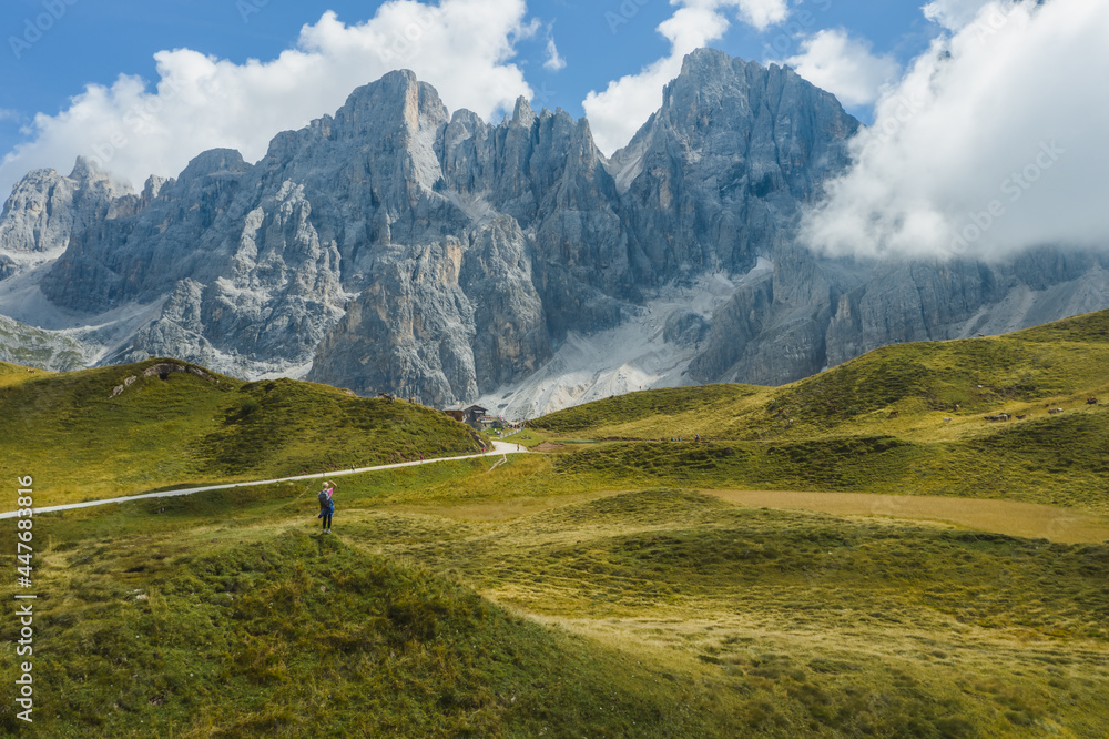 Woman traveler in front of pale di san martino near passo rolle dolomiti, italy, europe