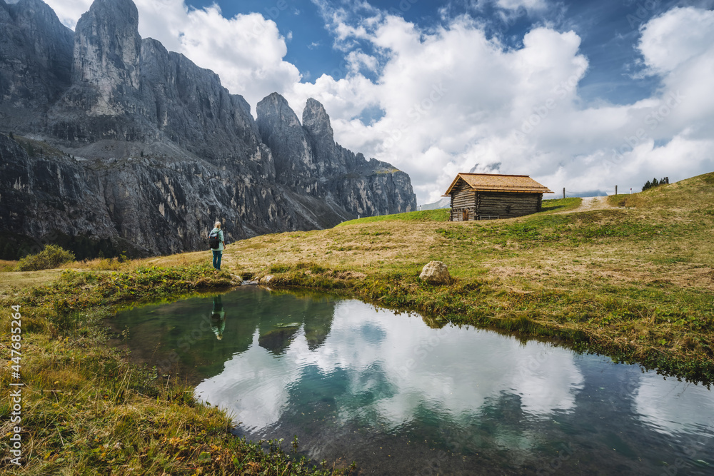 Woman enjoying Passo Gardena and Sella group mountains in Dolomites, south Tyrol, Italy, Europe