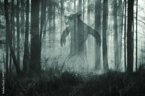 A horror concept. Of a giant werewolf, standing in a misty winter forest at night. With a grunge, textured edit. photo