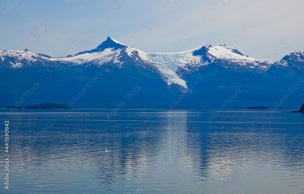 There are small islands on the lake, with glaciers and mountains in the background. The fjords of Alaska, unique natural landscapes. Alaska, USA. June 2019.