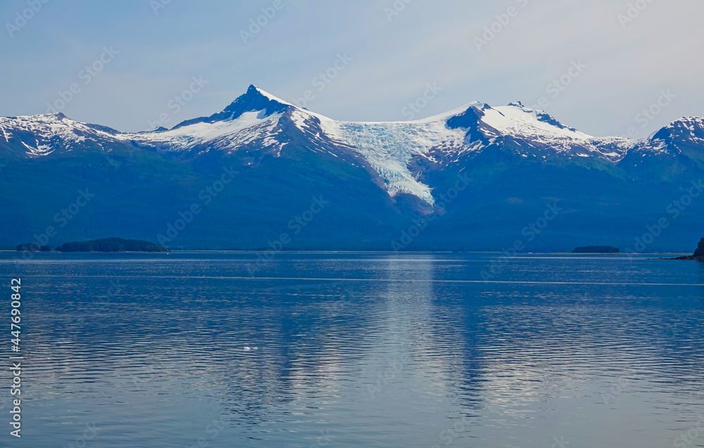 There are small islands on the lake, with glaciers and mountains in the background. The fjords of Alaska, unique natural landscapes. Alaska, USA. June 2019. There are small islands on the lake, with glaciers and mountains in the background. The fjords of Alaska, unique natural landscapes. Alaska, USA. June 2019.