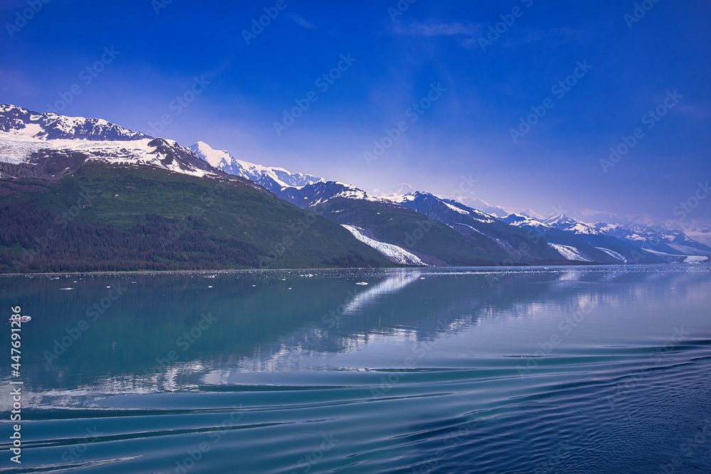 Cruise ships produce ripples on the surface of the lake. Snow-covered mountains. Enjoy the view of the ice shelf from the cruise ship. Alaska, USA. July 2019.