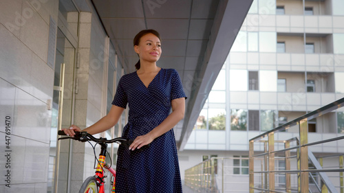 Mixed-race businesswoman commute to work on bicycle in summer