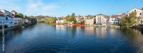 Traun river at Gmunden spa town, with houses at the riverside, austria in autumn