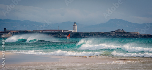 Person kitesurfing in front of lighthouse, Tarifa, Cadiz, Andalusia, Spain photo