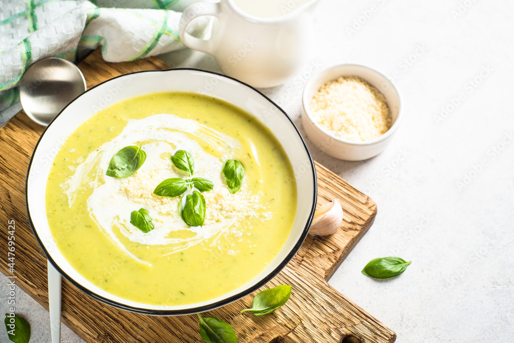 Zucchini soup with spinach and herb at white kitchen table. Zucchini soup with spinach and herb at white kitchen table.