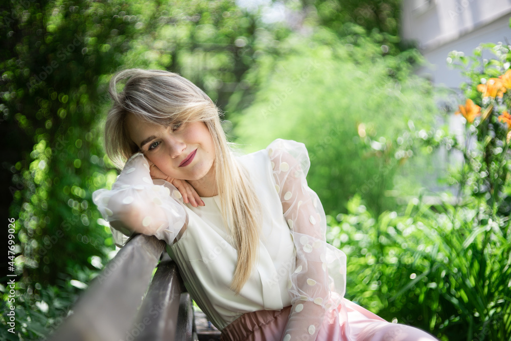 Close-up portrait of a young smiling girl in a white circuit board in a park in summer sunny weather, green around, pink-white dress. Close-up portrait of a young smiling girl in a white circuit board in a park in summer sunny weather, green around, pink-white dress.