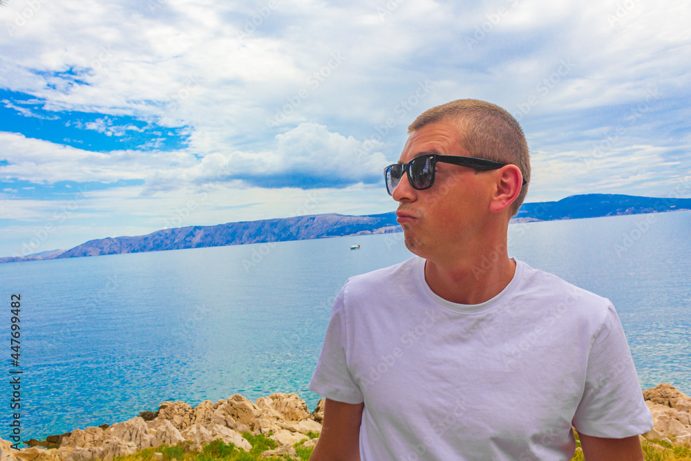 Young male model with sunglasses at Novi Vinodolski Croatia landscape.